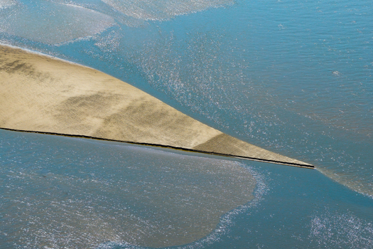 Aerial view of a sandbar emerging from low water in the river showcasing the natural patterns and textures of the riverbed in Poland.