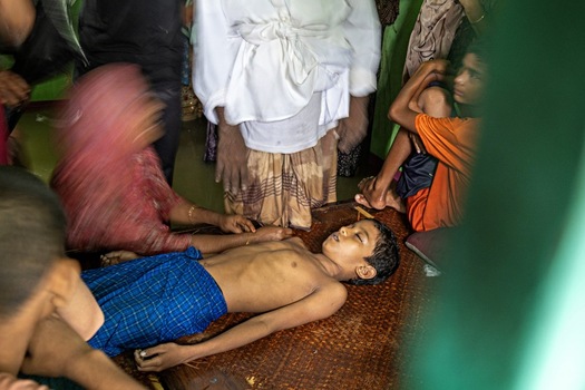 Banshkhali Upazila Chittagong Division Bangladesh 10 July 2026 View of a young boy lying on a mat surrounded by family members in a somber indoor setting. Banshkhali Upazila Chittagong Division Bangladesh 10 July 2026 View of a young boy lying on a mat surrounded by family members in a somber indoor setting.