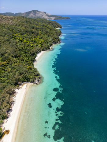 Aerial view of the lush tropical coastline and turquoise waters of Guanaja island under a clear blue sky in Guanaja Bay Islands Department Honduras. Aerial view of the lush tropical coastline and turquoise waters of Guanaja island under a clear blue sky in Guanaja Bay Islands Department Honduras.