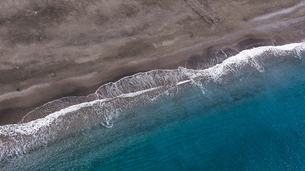 Aerial view of the dark sand meeting the turquoise sea white waves crashing creating a beautiful contrast Minori Campania Italy. Aerial view of the dark sand meeting the turquoise sea white waves crashing creating a beautiful contrast Minori Campania Italy.
