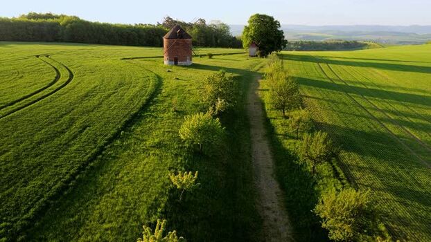 Aerial view of the historic brick windmill in green fields Czechia. Aerial view of the historic brick windmill in green fields Czechia.