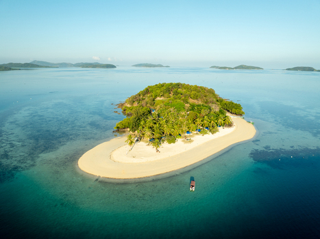 Aerial view of Pass Island featuring a white sand beach lush palm trees and turquoise waters in Coron Philippines. Aerial view of Pass Island featuring a white sand beach lush palm trees and turquoise waters in Coron Philippines.