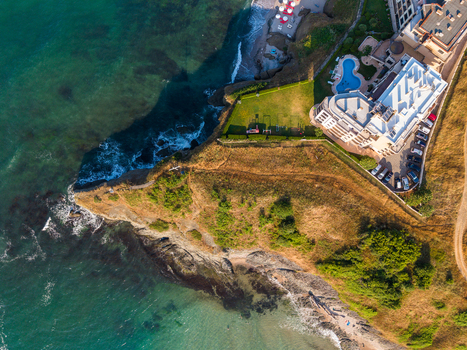 Aerial view of Lozenets Northern Cross featuring a coastal resort building with a swimming pool green lawns and rugged cliffs meeting the Black Sea in Lozenets Burgas Bulgaria. Aerial view of Lozenets Northern Cross featuring a coastal resort building with a swimming pool green lawns and rugged cliffs meeting the Black Sea in Lozenets Burgas Bulgaria.