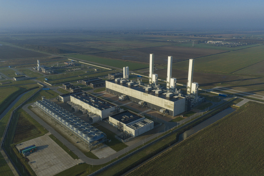 Aerial view of the Nitrogen plant facility featuring industrial structures and tall chimneys surrounded by flat agricultural fields in Zuidbroek Groningen Netherlands. Aerial view of the Nitrogen plant facility featuring industrial structures and tall chimneys surrounded by flat agricultural fields in Zuidbroek Groningen Netherlands.