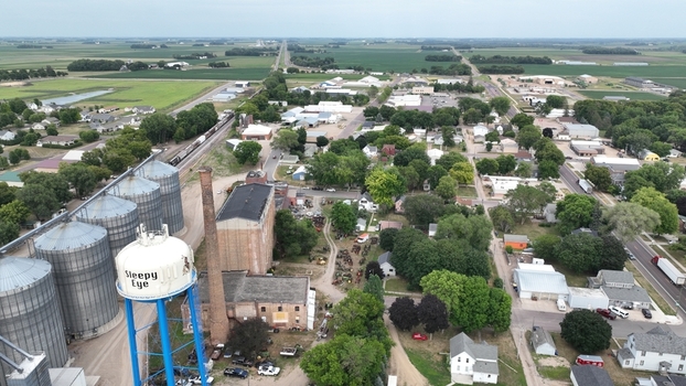 Aerial view of a town featuring grain elevators a water tower labeled Sleepy Eye and a railway snaking through fields Sleepy Eye Minnesota United States.