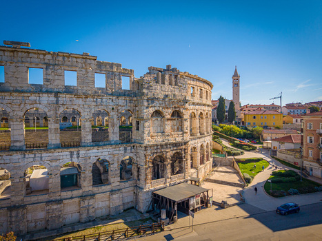Aerial view of the ancient Roman amphitheater s weathered stone contrasting with the vibrant blue sky a timeless monument standing proudly Pula Istria County Croatia.
