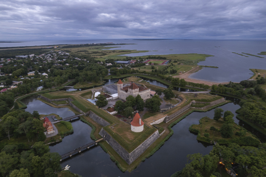 Aerial view of Kuressaare Castle surrounded by its historic moat stone fortifications and lush green parklands in the coastal town of Kuressaare Saare County Estonia.