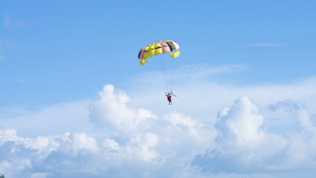 Cox s Bazar Bangladesh 18 August 2023 Aerial view of a parasailor suspended high above the fluffy white clouds under a sunny azure sky a dance of color and freedom. Cox s Bazar Bangladesh 18 August 2023 Aerial view of a parasailor suspended high above the fluffy white clouds under a sunny azure sky a dance of color and freedom.