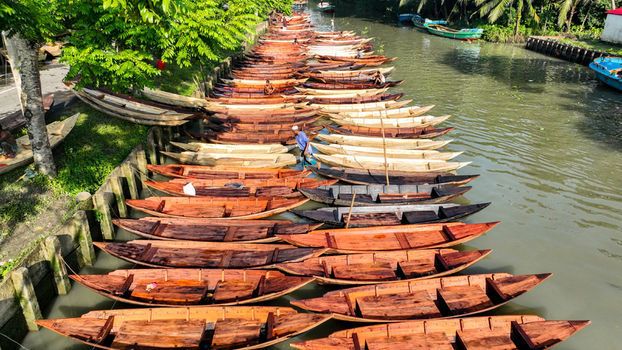 Aerial view of wooden boats tightly moored in the canal their rich brown hues contrasting with the murky water Pirojpur Pourashava Barisal Division Bangladesh. Aerial view of wooden boats tightly moored in the canal their rich brown hues contrasting with the murky water Pirojpur Pourashava Barisal Division Bangladesh.