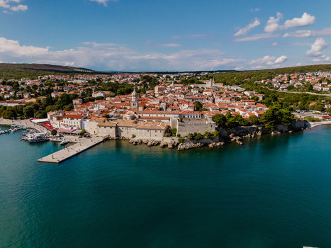Aerial view of the historic town of Krk with its stone buildings terracotta rooftops and harbor along the Adriatic Sea in Krk Primorje Gorski Kotar Croatia.