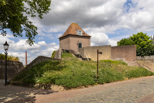View of the historic brick fortification with grassy ramparts and an old cannon in Heusden North Brabant Netherlands.