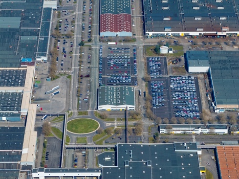 Aerial view of the stark geometric patterns of industrial buildings and car parks create a mesmerizing urban landscape a blend of human activity and architectural design Sausheim Grand Est France.
