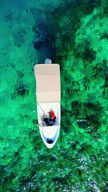 Aerial view of a small boat on turquoise water in Honduras. Aerial view of a small boat on turquoise water in Honduras.