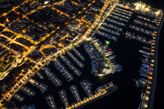 Aerial view of the illuminated marina in Antibes with numerous yachts docked in the harbor alongside the glowing city streets at night in Antibes Provence Alpes Cote d Azur France. Aerial view of the illuminated marina in Antibes with numerous yachts docked in the harbor alongside the glowing city streets at night in Antibes Provence Alpes Cote d Azur France.