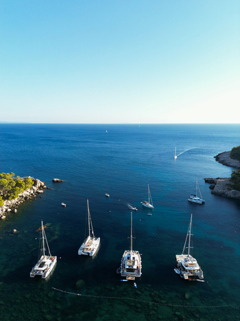 Aerial view of catamarans and sailboats anchored in a clear blue bay near Hvar Split Dalmatia County Croatia.
