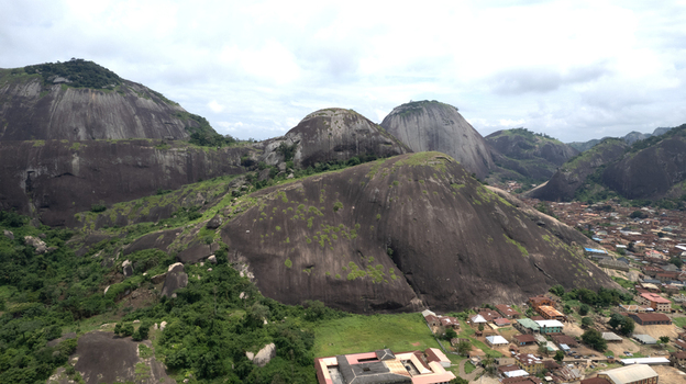 Aerial view of Idanre Hill featuring massive granite rock formations surrounded by lush greenery and the town buildings of Idanre Ondo State Nigeria. Aerial view of Idanre Hill featuring massive granite rock formations surrounded by lush greenery and the town buildings of Idanre Ondo State Nigeria.