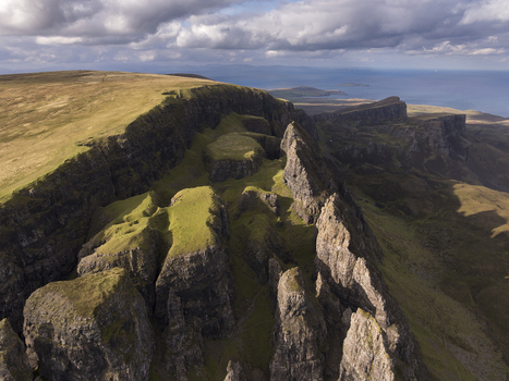 Aerial view of the Quiraing a dramatic landslip on the Isle of Skye featuring rugged rock formations and grassy slopes under a cloudy sky in Scotland United Kingdom. Aerial view of the Quiraing a dramatic landslip on the Isle of Skye featuring rugged rock formations and grassy slopes under a cloudy sky in Scotland United Kingdom.
