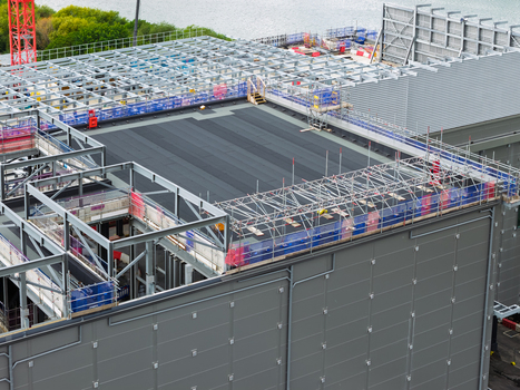 Aerial view of a data center under construction featuring a large steel frame structure scaffolding and a flat roof United Kingdom.