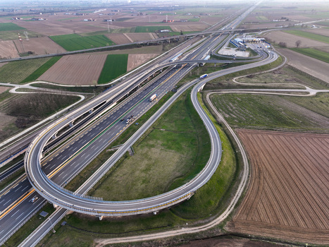 Aerial view of the Autostrada Torino Milano interchange with curved ramps and toll station surrounded by agricultural fields in Borgo d Ale Piedmont Italy. Aerial view of the Autostrada Torino Milano interchange with curved ramps and toll station surrounded by agricultural fields in Borgo d Ale Piedmont Italy.