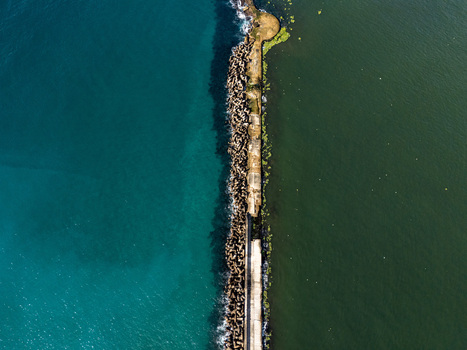 Aerial view of the Rio Ozama breakwater separating the turquoise Caribbean Sea from the darker river waters in Santo Domingo Santo Domingo Dominican Republic.