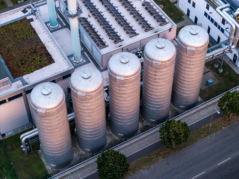 Berlin Germany 07 September 2026 Aerial view of BTB Heizkraftwerk Adlershof showing industrial metal storage tanks rooftop solar panels and surrounding infrastructure.