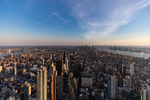 View of the expansive New York City skyline at sunset featuring iconic skyscrapers dense urban architecture and the Hudson River in New York New York United States. View of the expansive New York City skyline at sunset featuring iconic skyscrapers dense urban architecture and the Hudson River in New York New York United States.