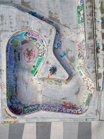 Aerial view of a concrete skatepark bowl covered in vibrant graffiti art and street tags Brussels Brussels Belgium.