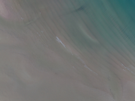 Aerial view of Gruinard Bay featuring sandy textures and turquoise water ripples in Gruinard Scotland United Kingdom. Aerial view of Gruinard Bay featuring sandy textures and turquoise water ripples in Gruinard Scotland United Kingdom.