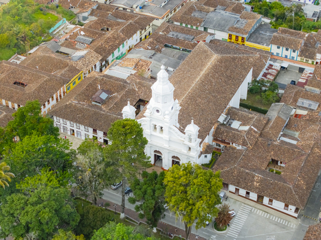 Aerial view of the Immaculate Conception Cathedral emerges a beacon of white amidst terracotta roofs and emerald trees Salamina Caldas Colombia.