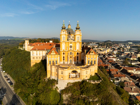 Aerial view of Melk Abbey a magnificent yellow baroque monastery perched on a rocky cliff overlooking the town of Melk Niederosterreich Austria. Aerial view of Melk Abbey a magnificent yellow baroque monastery perched on a rocky cliff overlooking the town of Melk Niederosterreich Austria.