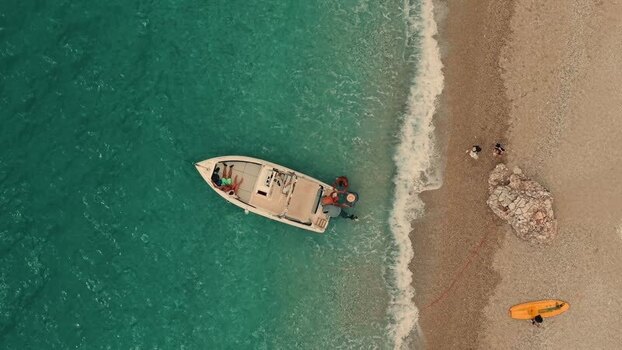 Aerial view of a motorboat near the pebble beach Albania. Aerial view of a motorboat near the pebble beach Albania.