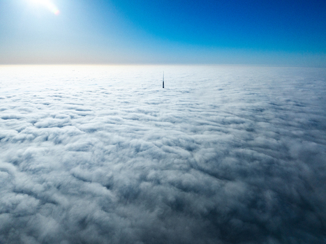 Aerial view of Riga Radio and TV Tower rising above a thick blanket of clouds under a clear blue sky in Riga Latvia. Aerial view of Riga Radio and TV Tower rising above a thick blanket of clouds under a clear blue sky in Riga Latvia.