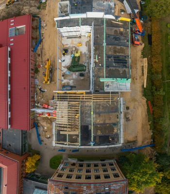 Aerial view of a construction site featuring building foundations cranes and surrounding structures in Latvia. Aerial view of a construction site featuring building foundations cranes and surrounding structures in Latvia.