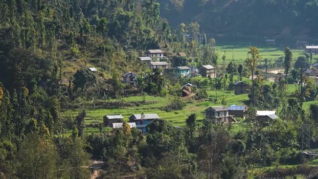 View of a rural village nestled in lush green hills Nepal.