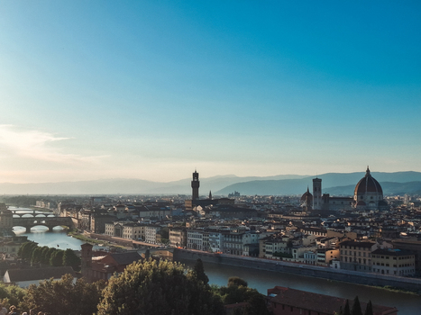 View of the historic skyline of Florence featuring the Duomo Palazzo Vecchio and Ponte Vecchio over the Arno River under a clear blue sky in Florence Tuscany Italy. View of the historic skyline of Florence featuring the Duomo Palazzo Vecchio and Ponte Vecchio over the Arno River under a clear blue sky in Florence Tuscany Italy.