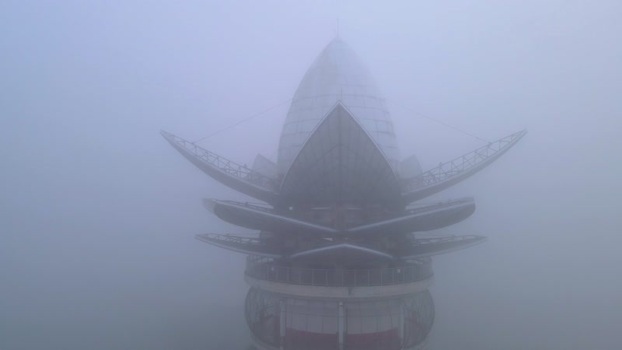 Aerial view of Menara Pandang Teratai tower in thick fog Indonesia.