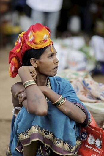 Odisha India 26 March 2026 View of a tribal woman adorned in vibrant attire bangles and a colorful headscarf her gaze fixed towards the distance. Odisha India 26 March 2026 View of a tribal woman adorned in vibrant attire bangles and a colorful headscarf her gaze fixed towards the distance.