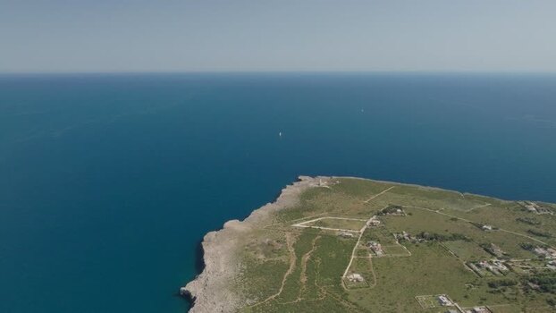 Aerial view of the rocky cliffs and blue sea in Italy.