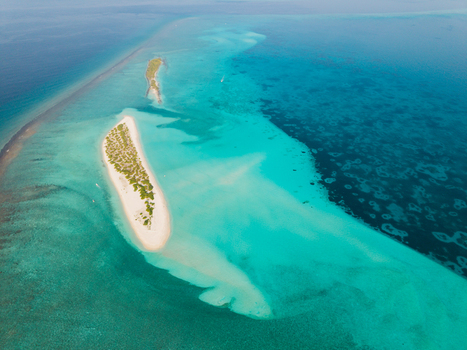 Aerial view of turquoise waters embracing the sandy shores of Kan island a tropical haven in the vast expanse of the Indian Ocean Dhidhdhoo Thiladhunmathi Atoll Maldives.