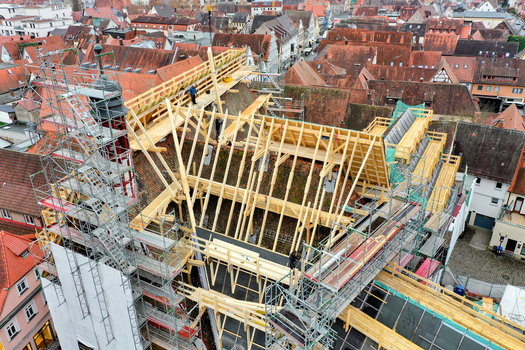 Aerial view of Rathaus Forchheim with workers installing wooden roof trusses amidst scaffolding and historic red tiled rooftops in Forchheim Bayern Germany. Aerial view of Rathaus Forchheim with workers installing wooden roof trusses amidst scaffolding and historic red tiled rooftops in Forchheim Bayern Germany.