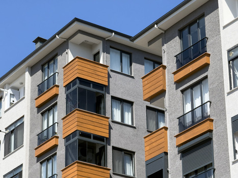View of modern residential building facade with grey walls and orange balcony accents under a clear blue sky in Avcilar Istanbul Turkiye. View of modern residential building facade with grey walls and orange balcony accents under a clear blue sky in Avcilar Istanbul Turkiye.