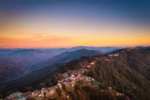 Aerial view of the hill station of Chakrata with colorful buildings nestled on a mountain ridge under a golden sunset sky in Chakrata Uttarakhand India. Aerial view of the hill station of Chakrata with colorful buildings nestled on a mountain ridge under a golden sunset sky in Chakrata Uttarakhand India.