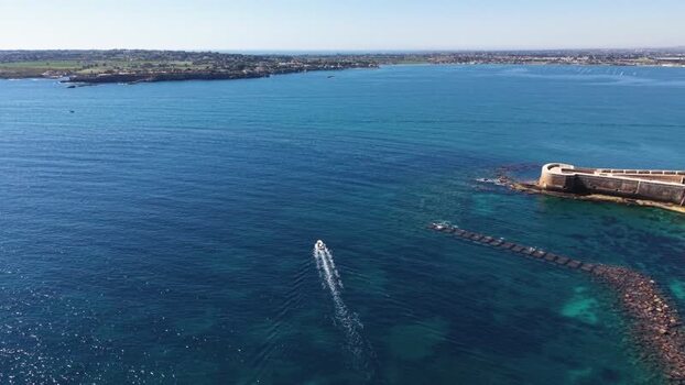 Aerial view of a boat near Castello Maniace in Syracuse Italy.