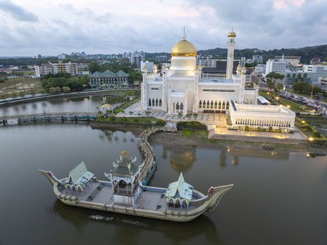 Aerial view of the Sultan Omar Ali Saifuddien Mosque with its golden dome and ceremonial stone boat in the lagoon at dusk in Bandar Seri Begawan Brunei Muara District Brunei. Aerial view of the Sultan Omar Ali Saifuddien Mosque with its golden dome and ceremonial stone boat in the lagoon at dusk in Bandar Seri Begawan Brunei Muara District Brunei.
