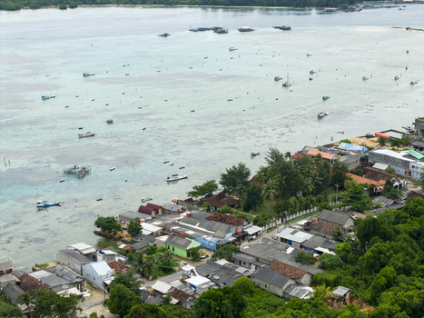 Aerial view of a serene coastal village nestled between the turquoise waters and lush greenery a tranquil scene unfolding Karimunjawa Central Java Indonesia. Aerial view of a serene coastal village nestled between the turquoise waters and lush greenery a tranquil scene unfolding Karimunjawa Central Java Indonesia.
