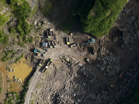Aerial view of Tambang Pasir Merapi Kali Gendol Sand Mine with excavators loading trucks on a rocky terrain surrounded by lush greenery Kecamatan Cangkringan Daerah Istimewa Yogya Indonesia. Aerial view of Tambang Pasir Merapi Kali Gendol Sand Mine with excavators loading trucks on a rocky terrain surrounded by lush greenery Kecamatan Cangkringan Daerah Istimewa Yogya Indonesia.