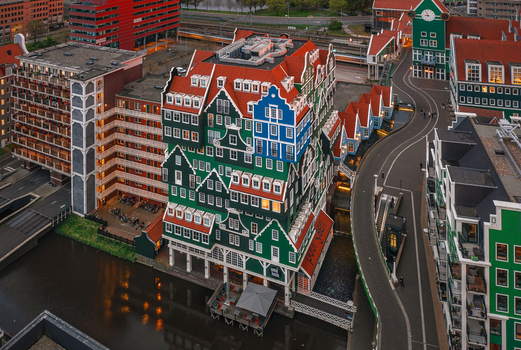Zaandam Netherlands 26 April 2022 Aerial view of Inntel Hotels Amsterdam Zaandam featuring its unique stacked traditional house facade next to a canal and city streets.