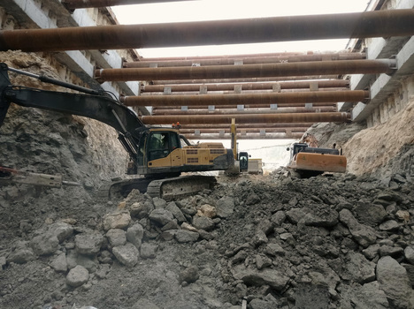 View of heavy excavators working at an underground construction site with large metal support pipes and concrete walls in Avcilar Istanbul Turkiye. View of heavy excavators working at an underground construction site with large metal support pipes and concrete walls in Avcilar Istanbul Turkiye.