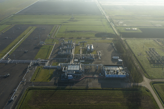 Aerial view of the natural gas mining facility with industrial infrastructure pipelines and storage tanks surrounded by green fields in Slochteren Groningen Netherlands. Aerial view of the natural gas mining facility with industrial infrastructure pipelines and storage tanks surrounded by green fields in Slochteren Groningen Netherlands.