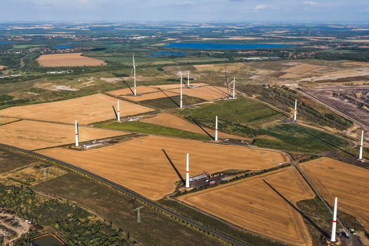 Aerial view of wind turbines installed in golden agricultural fields adjacent to the Schleenhain lignite open cast mine in Zwenkau Saxony Germany.